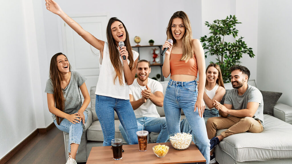 Amigos cantando karaokê de músicas brasileiras na sala de casa